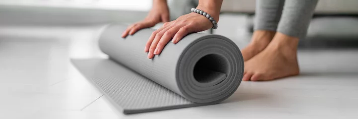 Fototapeten Yoga Online-Klasse zu Hause Frau Rollmatte auf Wohnungsboden für Fitnesstraining oder Meditationsbanner Panorama. Füße und Hände Nahaufnahme © Maridav