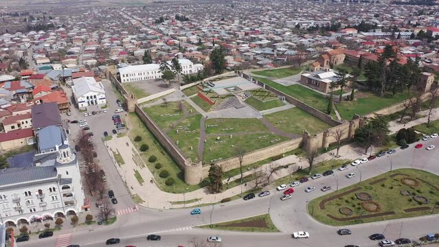 Scenic view from drone of central areas of Telavi city overlooking medieval walled Batonis Tsikhe fortress on spring day, Georgia