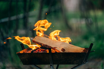 夏のキャンプで焚き火をする男性（夜・夕方）
