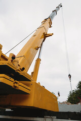 Construction crane lifting heavy freight. Modern mobile transportation technologies help building...