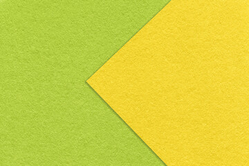 Texture of yellow and green paper background, half two colors with arrow, macro. Structure of dense craft cardboard.