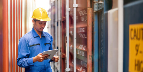 Maintenance engineer using tablet to conduct inspecting checklist at container yard warehouse.