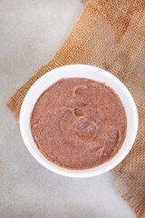 Traditional  African Sorghum breakfast porridge or Mabele, on mottled grey with copy space