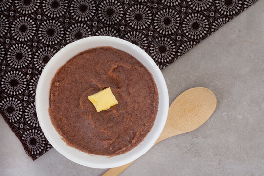 Traditional  African Sorghum breakfast porridge or Mabele, on mottled grey with traditional South African printed cloth and copy space