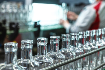 Long row of empty glass bottles for alcohol drinks at plant