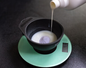 Woman prepares hair dye, top view.