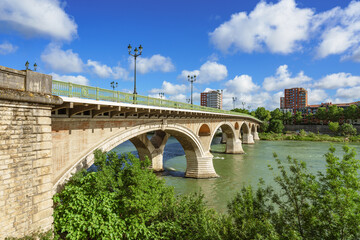 Naklejka premium Bridge spans over a river in a city in springtime. Pont des Catalans, Toulouse, France