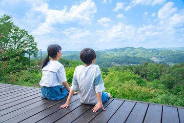 山の頂上からの景色を見ている日本人の小学生