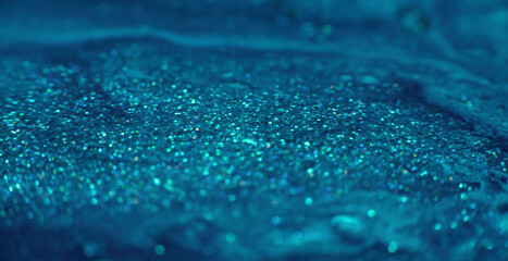 Flowing sparkles background. Glitter paint motion. Sparkling blue specks moving shot on RED Cinema camera.