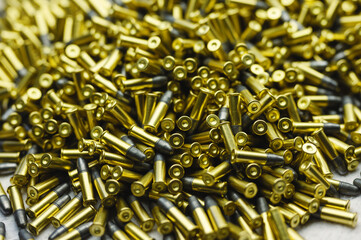 Small-caliber bullets on white table at production plant
