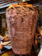 Doner kebab meat on skewers in front of the grill in the restaurant. close up