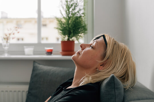 Close up of middle age 40s mature woman face with closed eyes relaxing at home