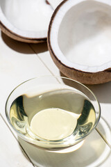 割られたココナッツから見える胚乳とココナッツオイル