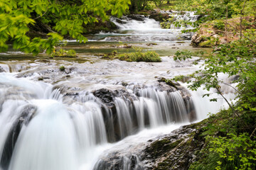 北海道伊達市、木々の合間を流れる三階滝川【6月】