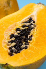 青色の背景にカットした黄色の完熟パパイア