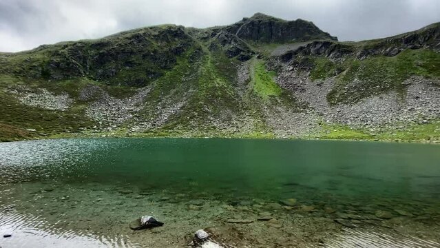 Beautiful turquoise Mittlerer Plenderlessee with nice reflections and great mountains in the background, very close to K&uuml;htai in Tyrol, Austria
