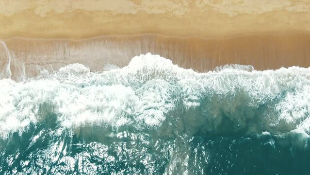 Aerial top down view wave sea breaking golden sandy coastline. Landscape beach sand shore sunshine.