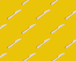 Top view of a plastic knife on a yellow background. Background,pattern,texture