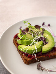 Sandwiches with boiled beetroot and avocado with microgreens, delicious healthy breakfast