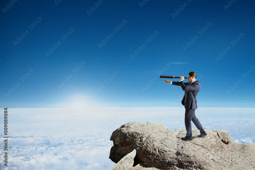Poster businessman with telescope standing on cliff, looking and pointing finger into the distance on brigh