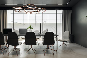Front view on modern black marble meeting table with laptops surrounded by stylish chairs in conference room with bronze chandelier on top, light floor and glass door. 3D rendering
