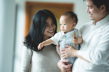 young Asian family are happy together at home by life insurance concept, child baby and mother and...