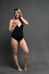 Fototapeta na wymiar Caucasian woman in full growth in a swimsuit with a smile looks to the side
