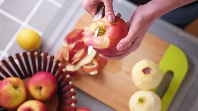 Apple pie preparation series - woman is peeling an apple by knife