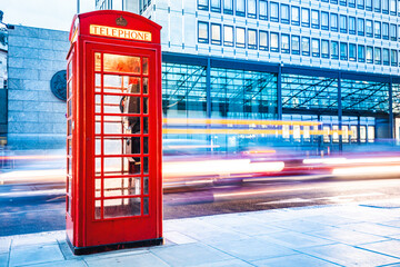 London red telephone booth and red bus in motion
