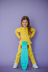 Cute little girl with skateboard in studio