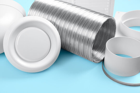 Parts of home ventilation system on light blue background, closeup