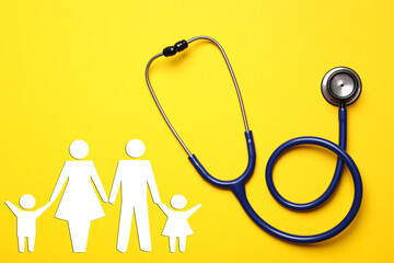 Health insurance. Stethoscope and illustration of family on yellow background, top view