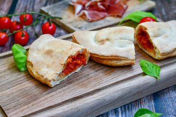 Fototapeta na wymiar Home made italian calzone vegetarian pizza with tomatoes, mozzarella and parmesan cheese and fresh basil 