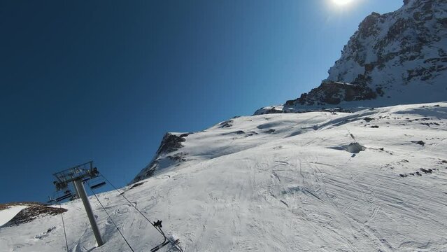 Aerial view sport FPV drone raising up top of mount. Beautiful peaks of the alps covered with snow cover