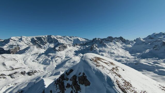 Aerial view sport FPV drone raising up top of mount. Beautiful peaks of the alps covered with snow cover