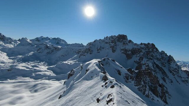 Aerial view sport FPV drone raising up top of mount. Beautiful peaks of the alps covered with snow cover