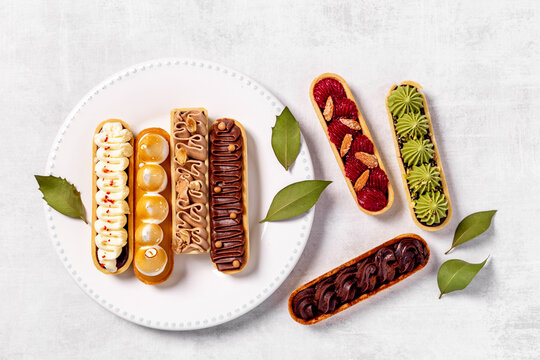 Sweet bakery eclairs with creamy decor, top view