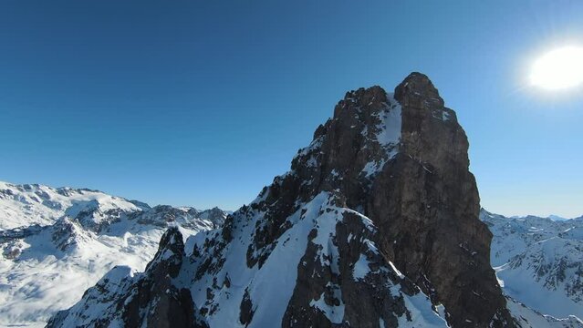 Aerial view sport FPV drone raising up top of mount. Beautiful peaks of the alps covered with snow cover