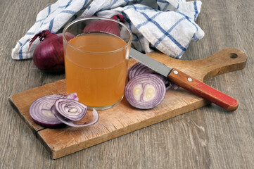 Verre de jus d'oignons rouges et ses ingrédients sur une planche à découper