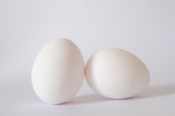 Close up view of white raw chicken eggs isolated on white background with soft shadow, selective focus.