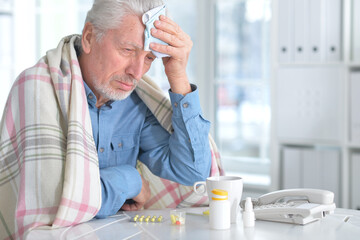 Sick elderly man with pills