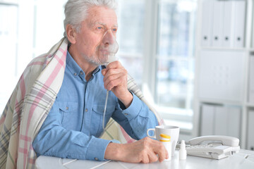 Elderly man doing inhalation