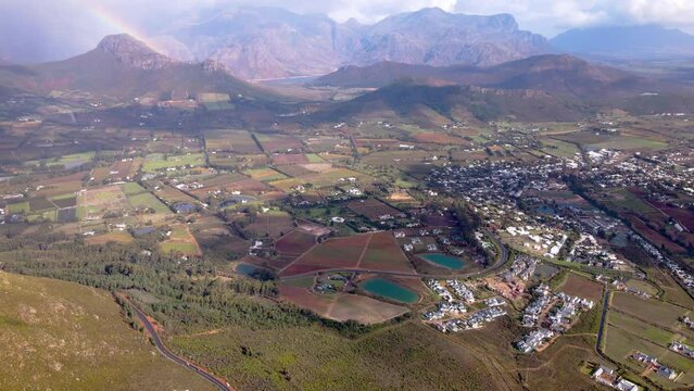 Stunning reveal from pass over Franschhoek, rainbow and mountains; aerial