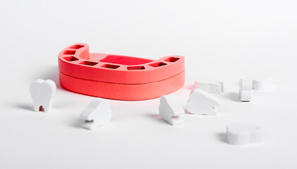 Toothless wooden jaw model and white teeth on surface. Oral hygiene, dental care, stomatology,...