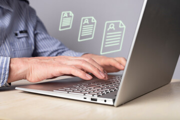 Manager using laptop for receiving CV from job candidates, scanning resumes. Human resources, employees hiring concept. Man hands at computer keyboard. High quality photo
