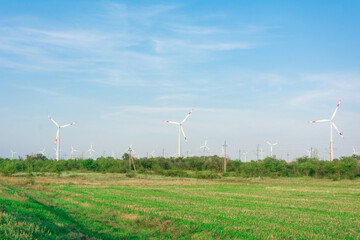 Wind turbines generators on green meadow. Source of alternative electricity. Ecological renewable power sources