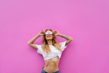 Young woman near pink wall.