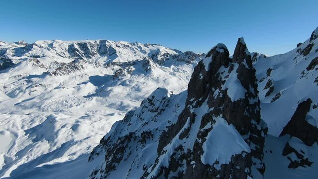 Aerial view sport FPV drone raising up top of mount. Beautiful peaks of the alps covered with snow cover