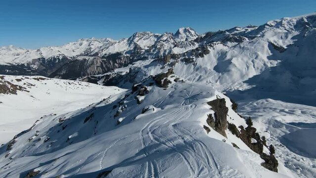 Aerial view sport FPV drone raising up top of mount. Beautiful peaks of the alps covered with snow cover
