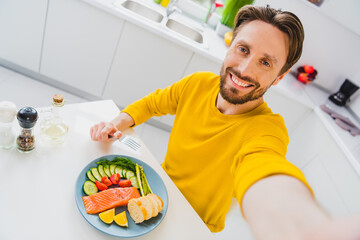 Photo of young handsome man eat healthy food supper make take selfie blogger kitchen restaurant...